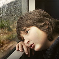 sad boy looking out window